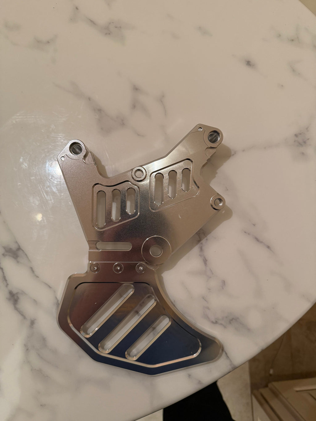 Surgeracingco Talaria xxx footbrake with sleek design, mounted on a racing motorcycle for optimal stopping power.