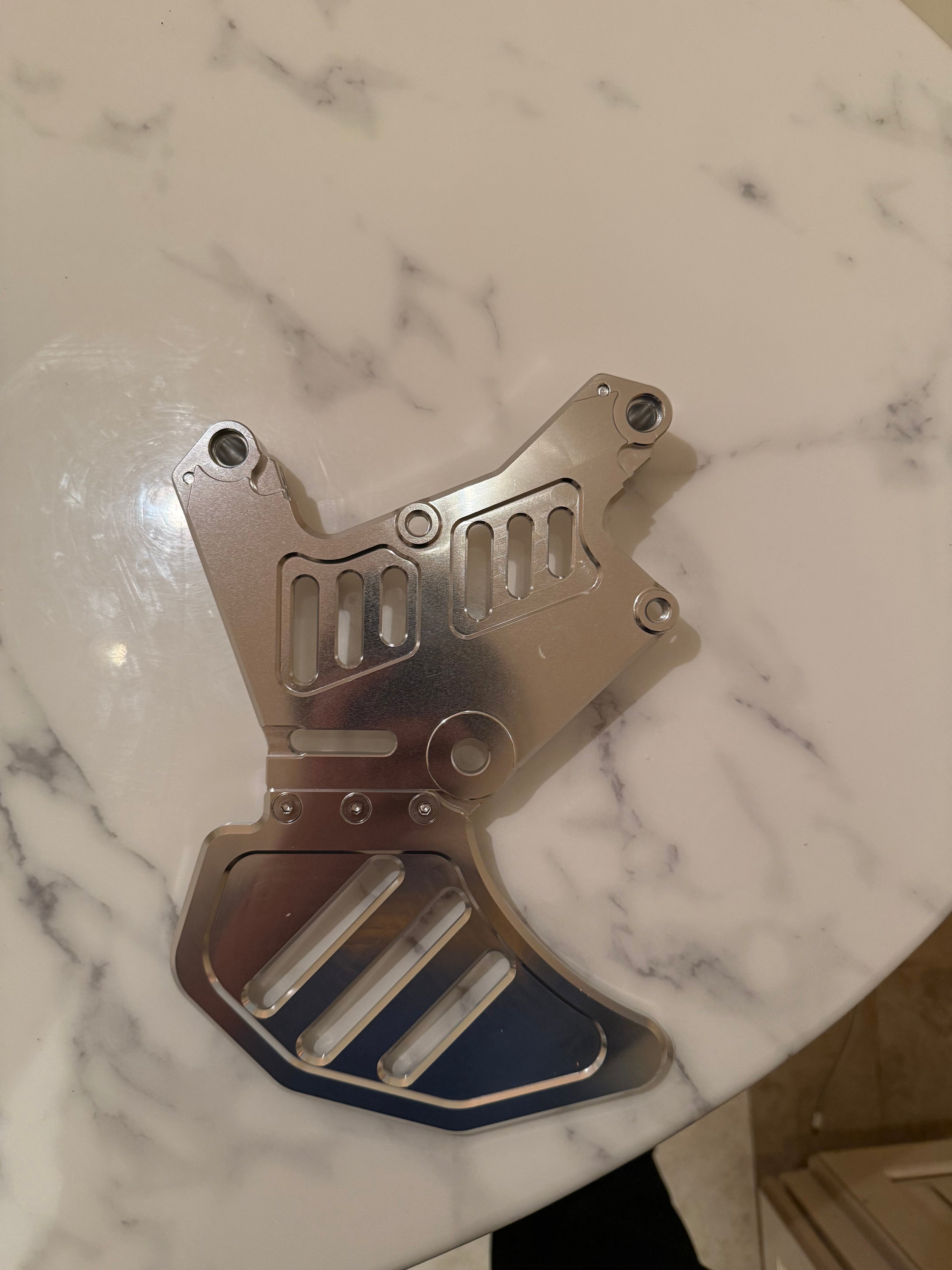 Surgeracingco Talaria xxx footbrake with sleek design, mounted on a racing motorcycle for optimal stopping power.