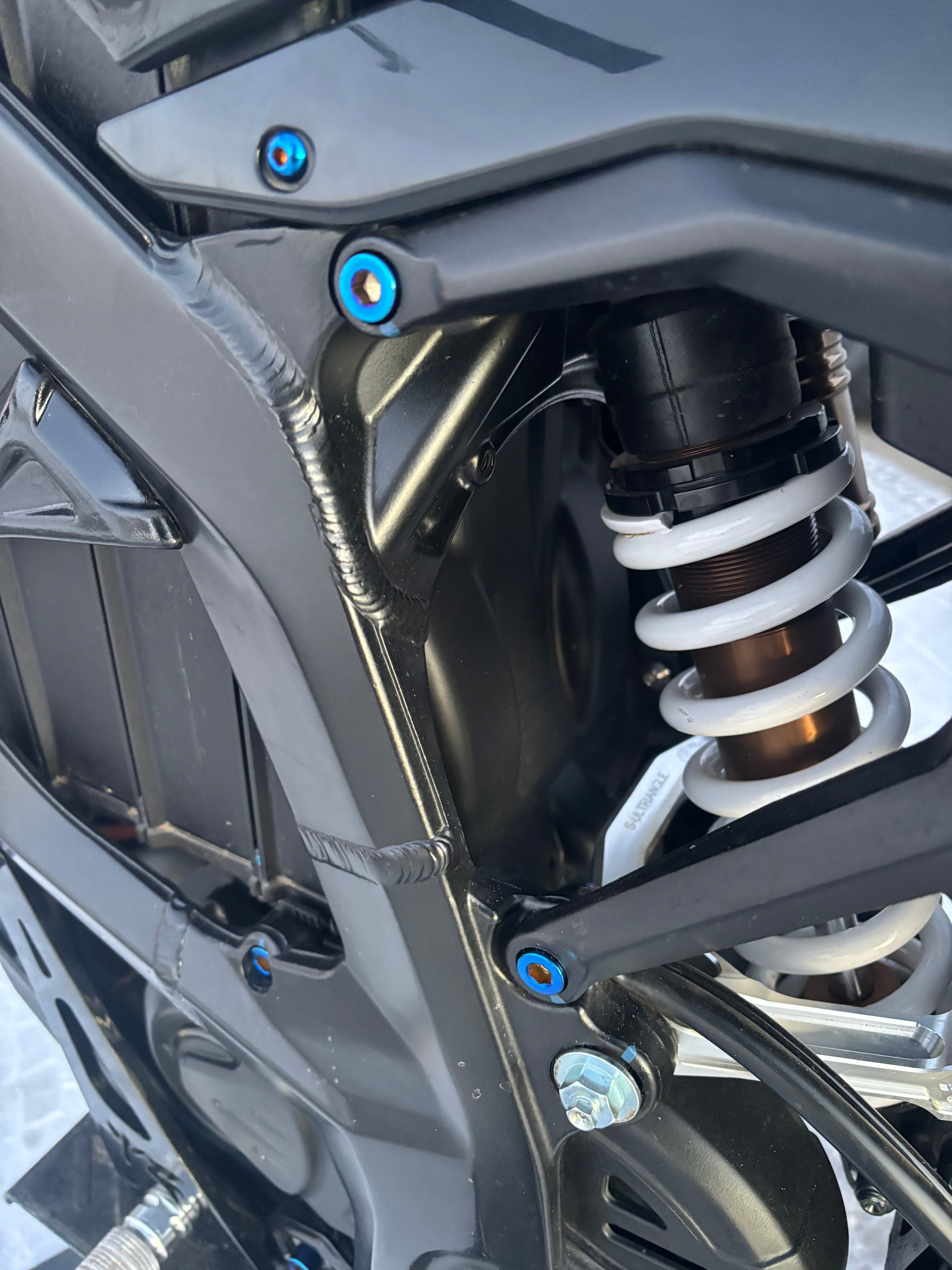 Set of four DevMoto All Emoto Subframe Titanium Bolts for motorcycle subframe attachment, lightweight and durable.