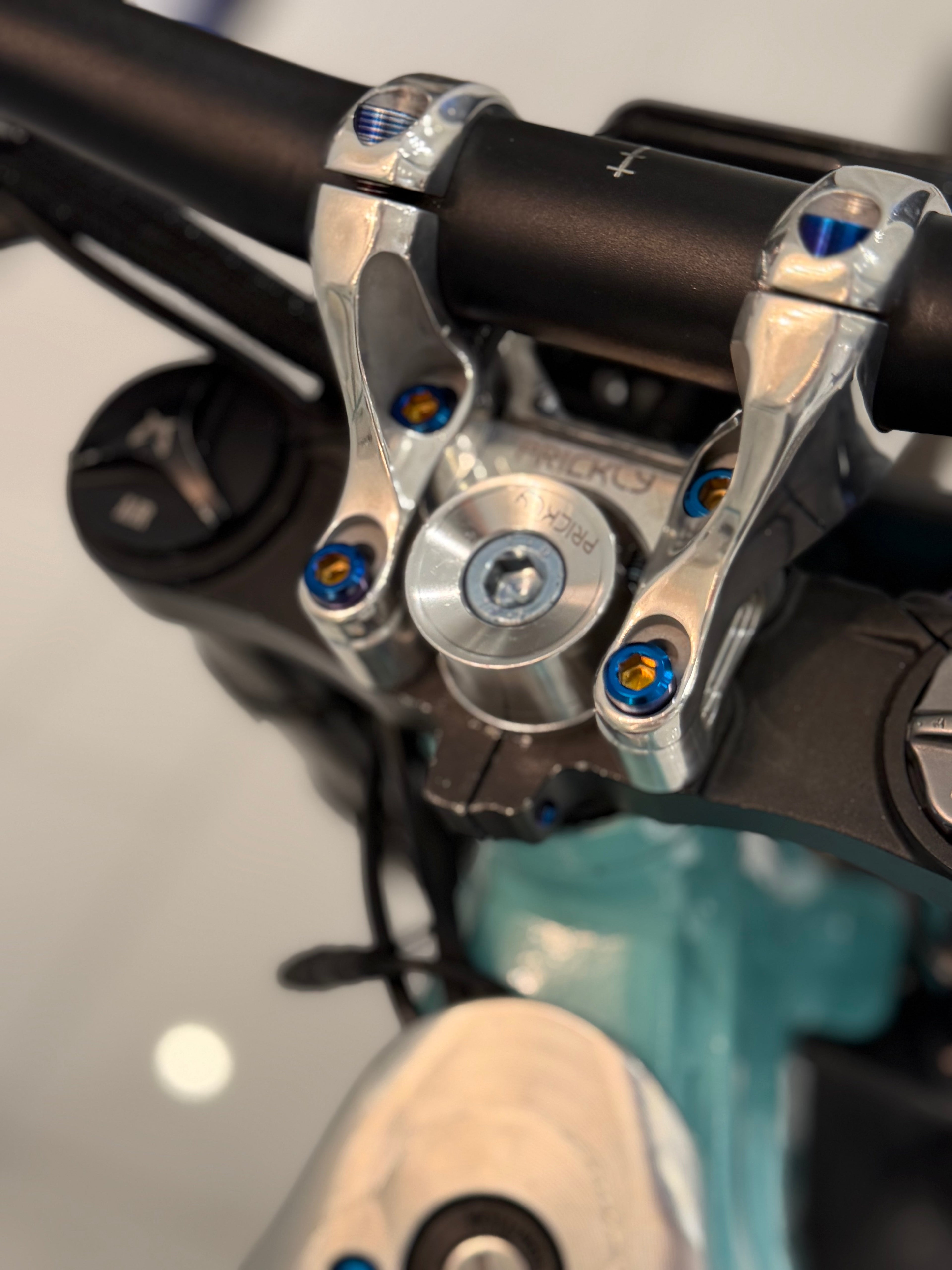 Set of four DevMoto direct mount riser bolts for motorcycle handlebars, shown in close-up detail.