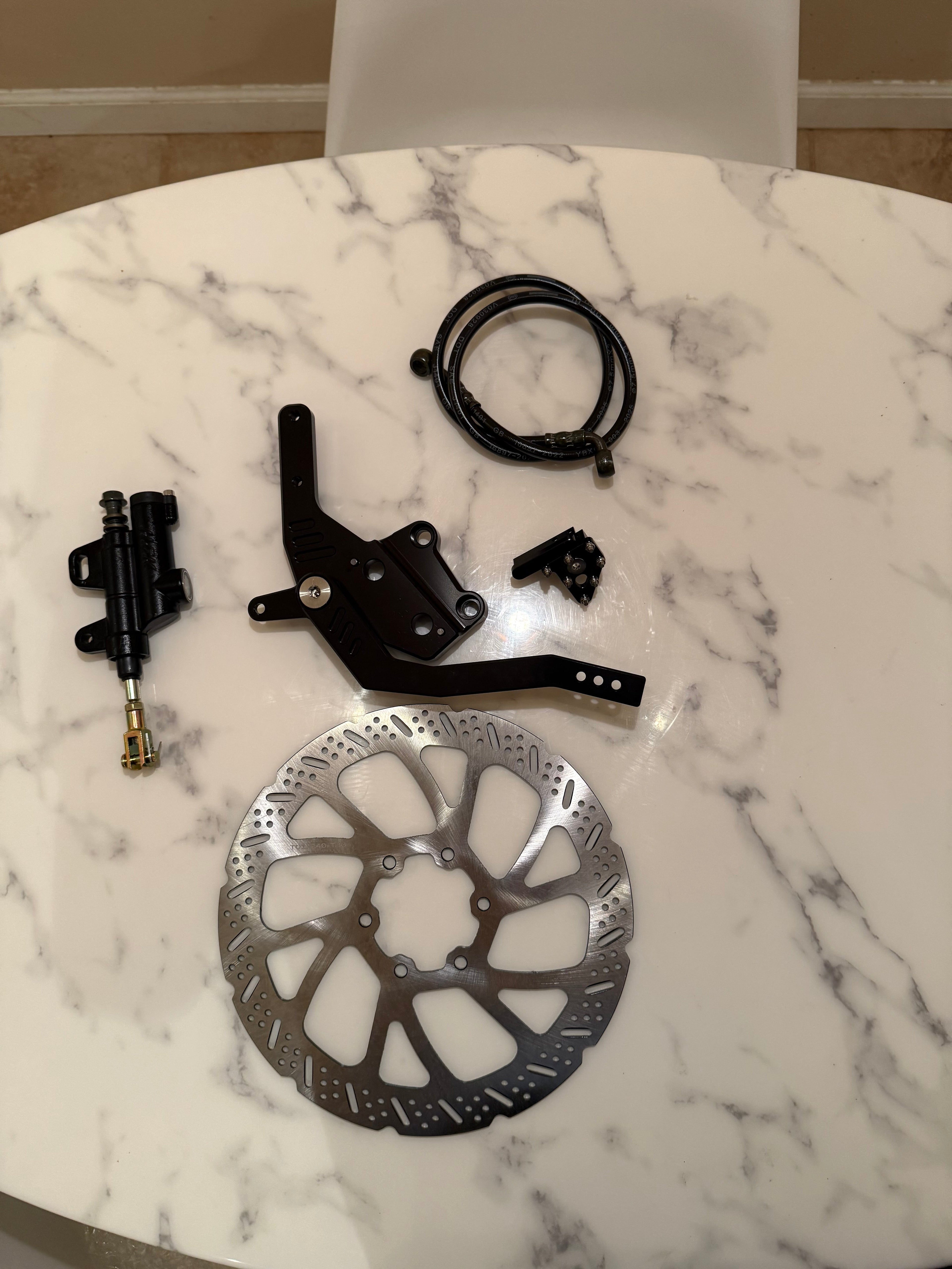 Surgeracingco Talaria XXX footbrake with sleek design and metal construction for motorcycle braking system.