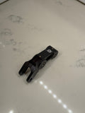 DevMoto E-Moto suspension linkage showing the metal linkage component with bolts on a neutral background.