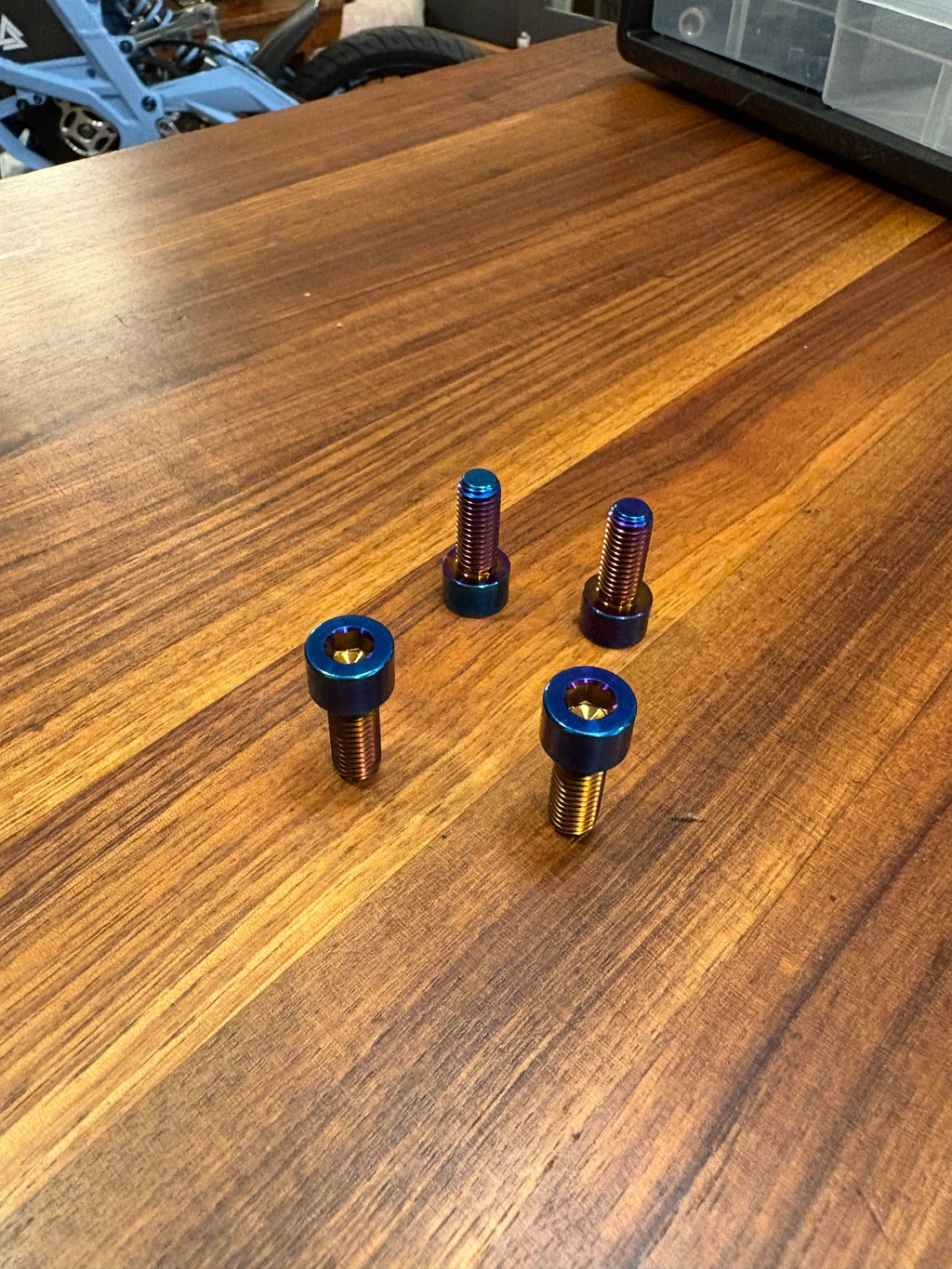 Set of four DevMoto Talaria XXX lower frame bolts for motorcycle frame assembly, shown in a close-up image.