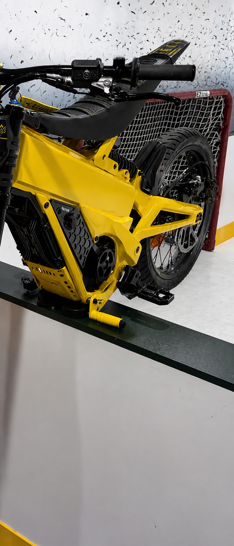 TG Racing Talaria X3 footlock and bracket shown in black, with metal construction and mounting hardware for secure installation.