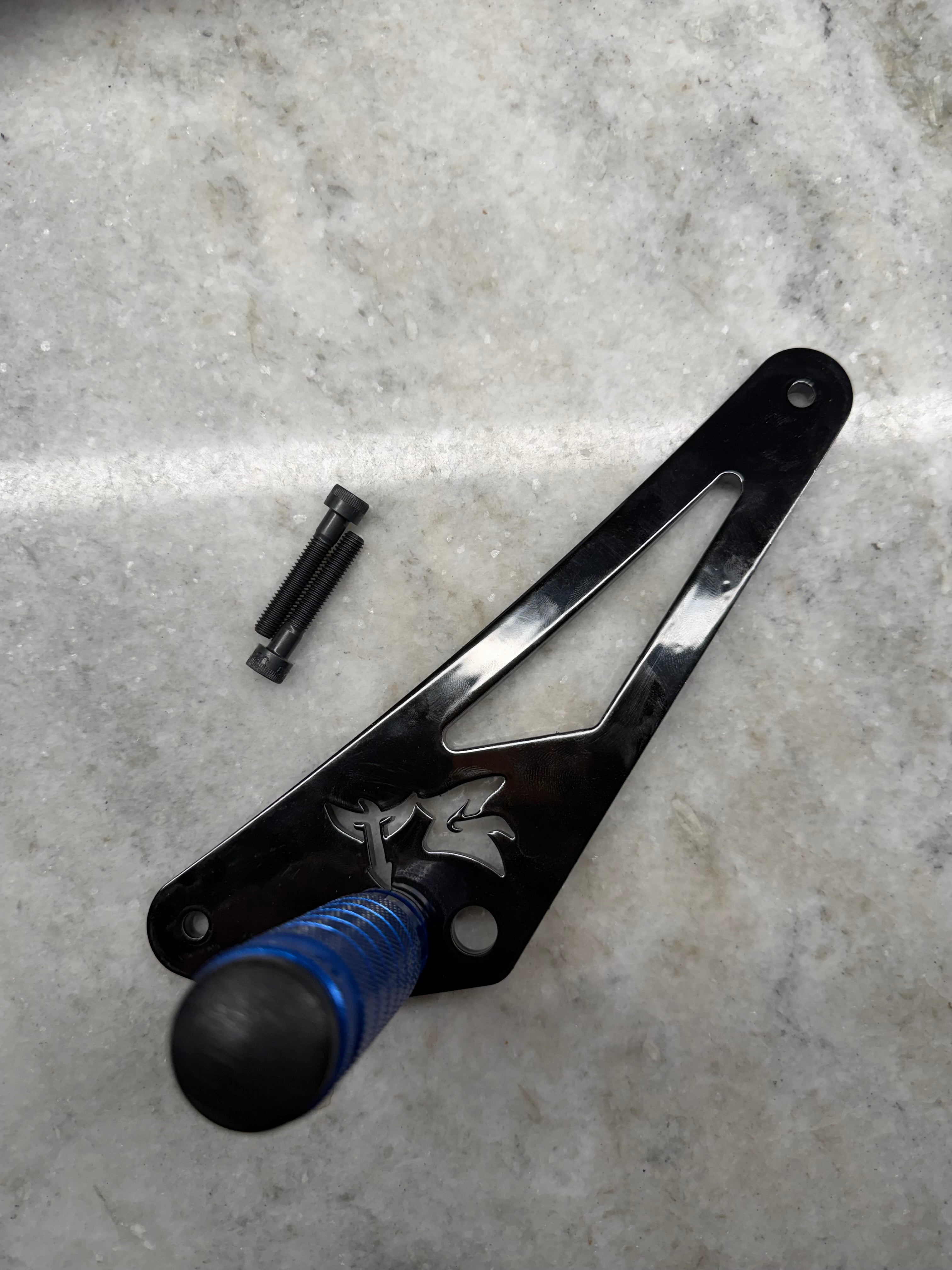 TG Racing 79 Bike Ventus Shift Lock, black metal lock with key, designed to secure motorcycle gear shifters.