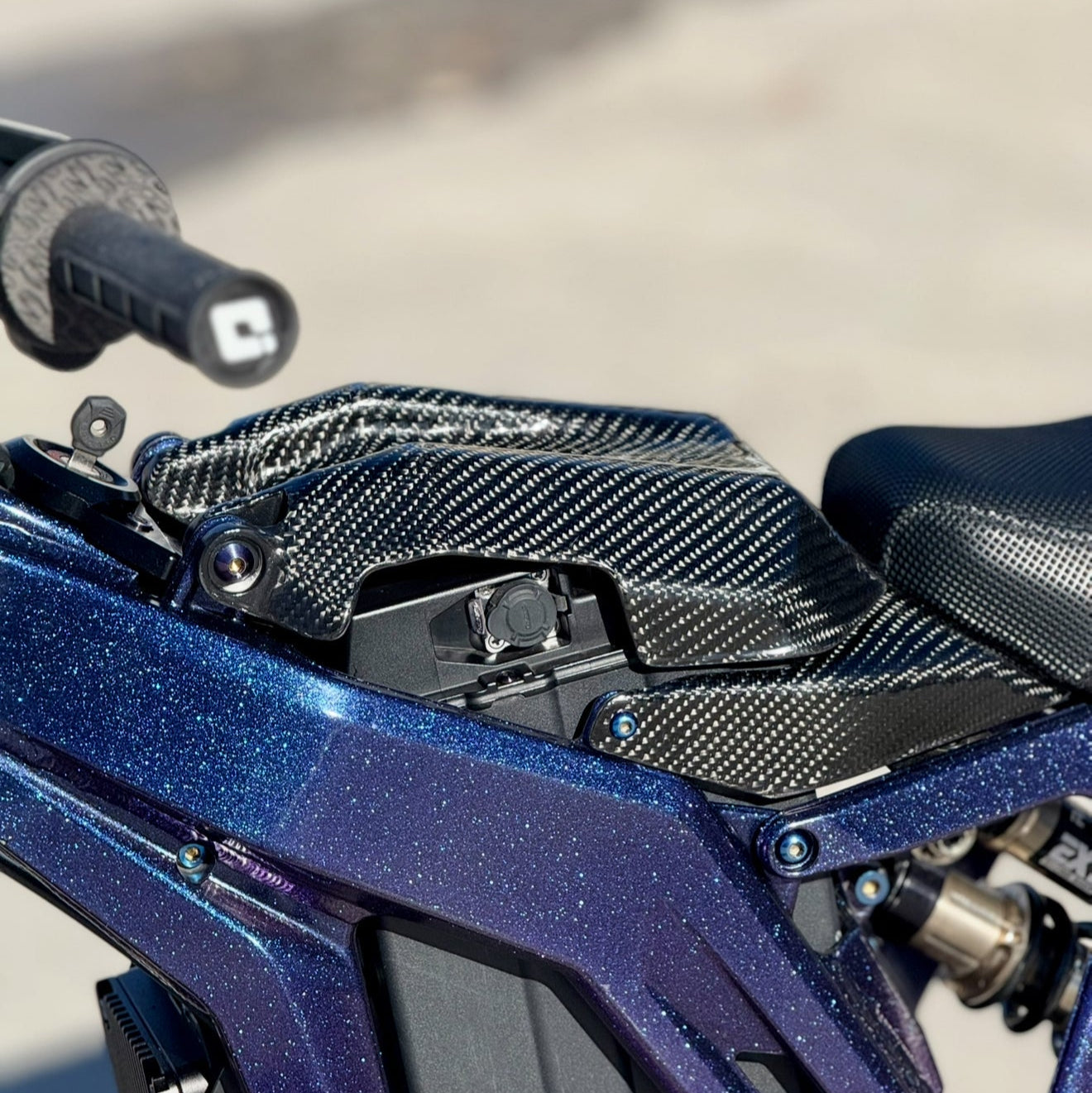 Modded Moto Co E-Ride Pro carbon fiber battery lid accessory, lightweight and durable for electric motorcycle battery protection.