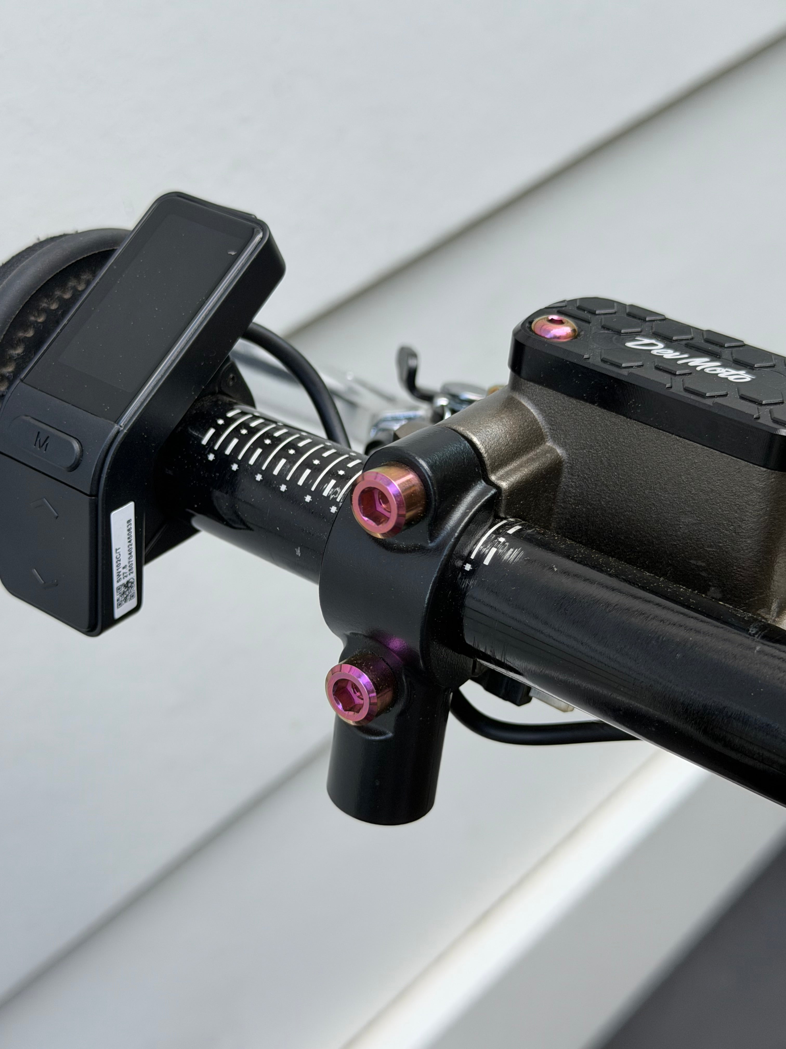 DevMoto Ultra Bee Brake Mount with titanium bolts, close-up of sleek, durable bike brake component and hardware.