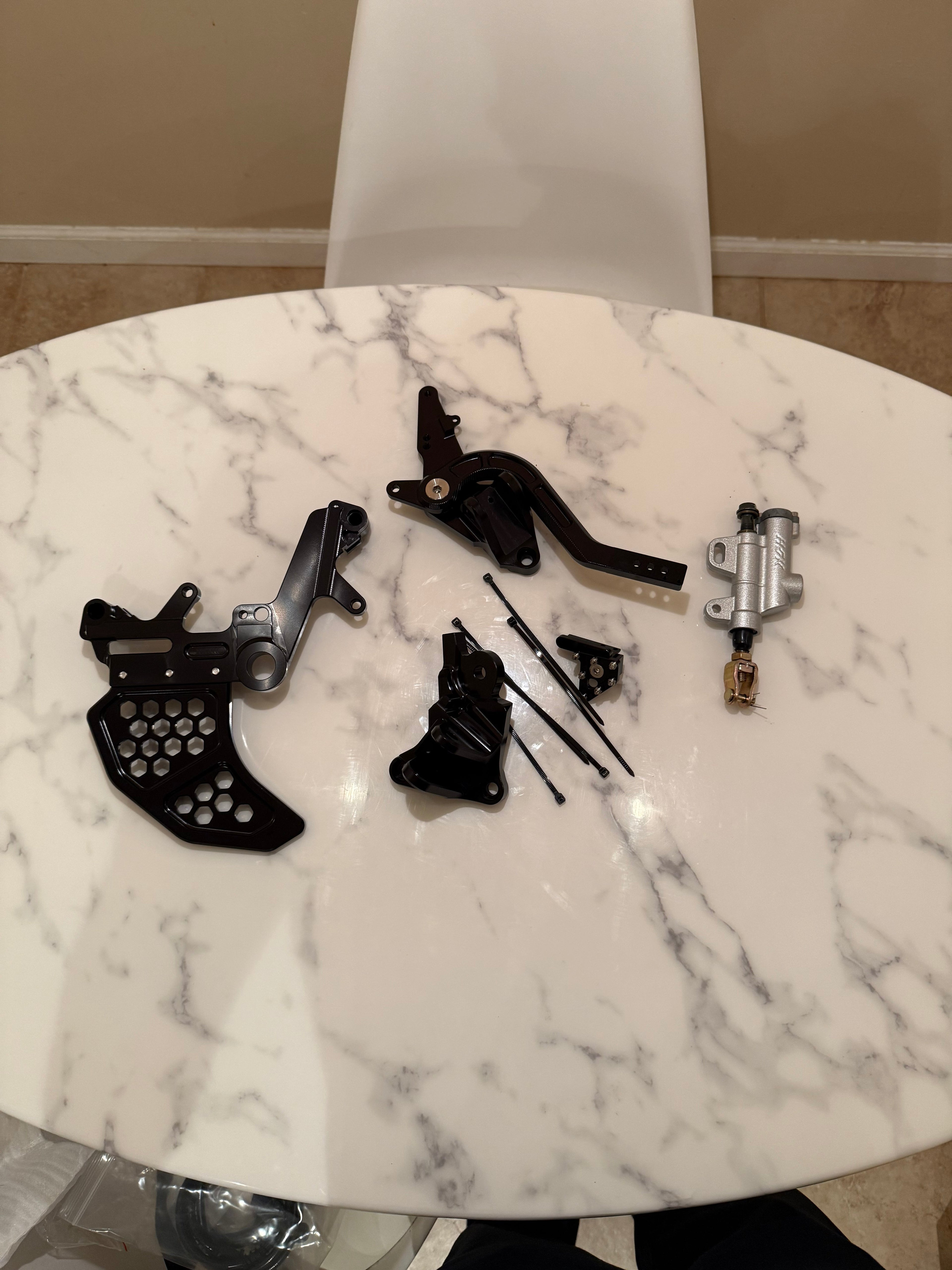 Surgeracingco Surron Ultra Bee Footbrake Kit V3 installed on electric bike with metal brake lever and mounting hardware.
