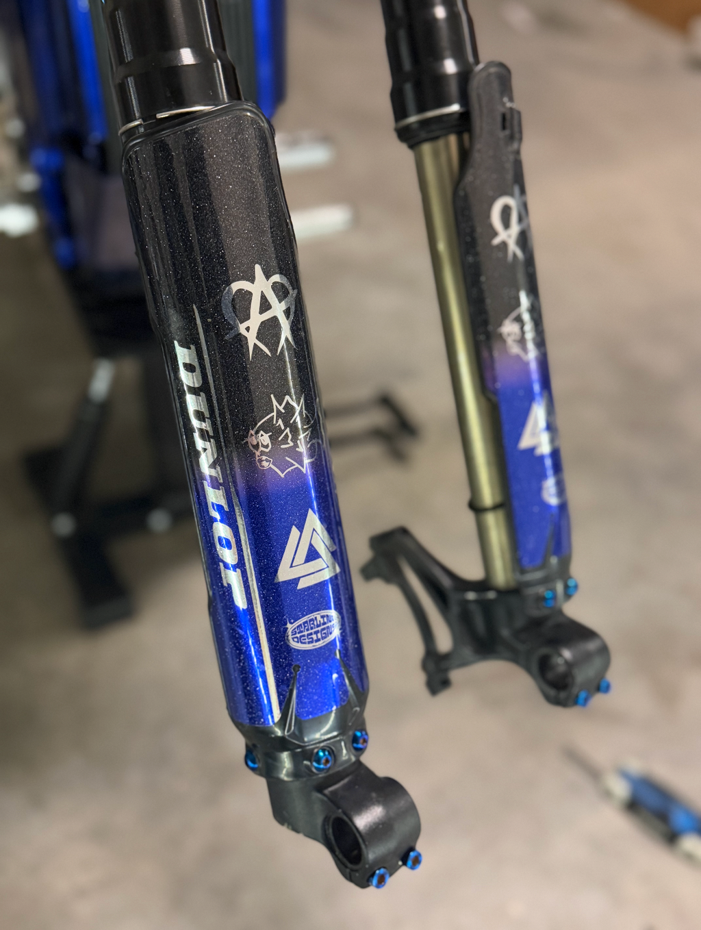 Set of six DevMoto All Emoto titanium fork guard bolts, lightweight and durable motorcycle wheel fasteners.