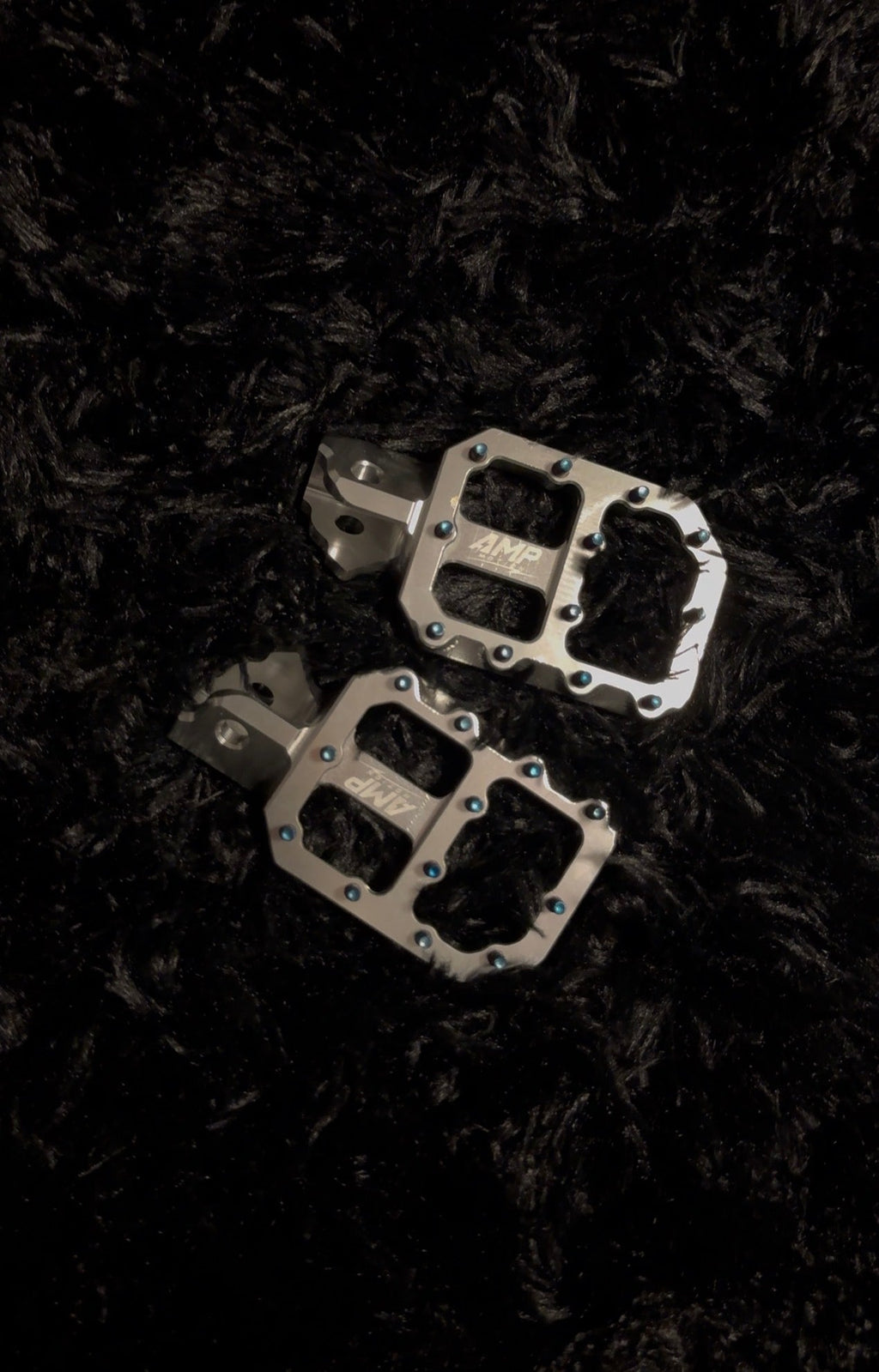 Aluminum pegs from Amp Motion, featuring sleek metal construction and a durable design for bike or skateboard use.