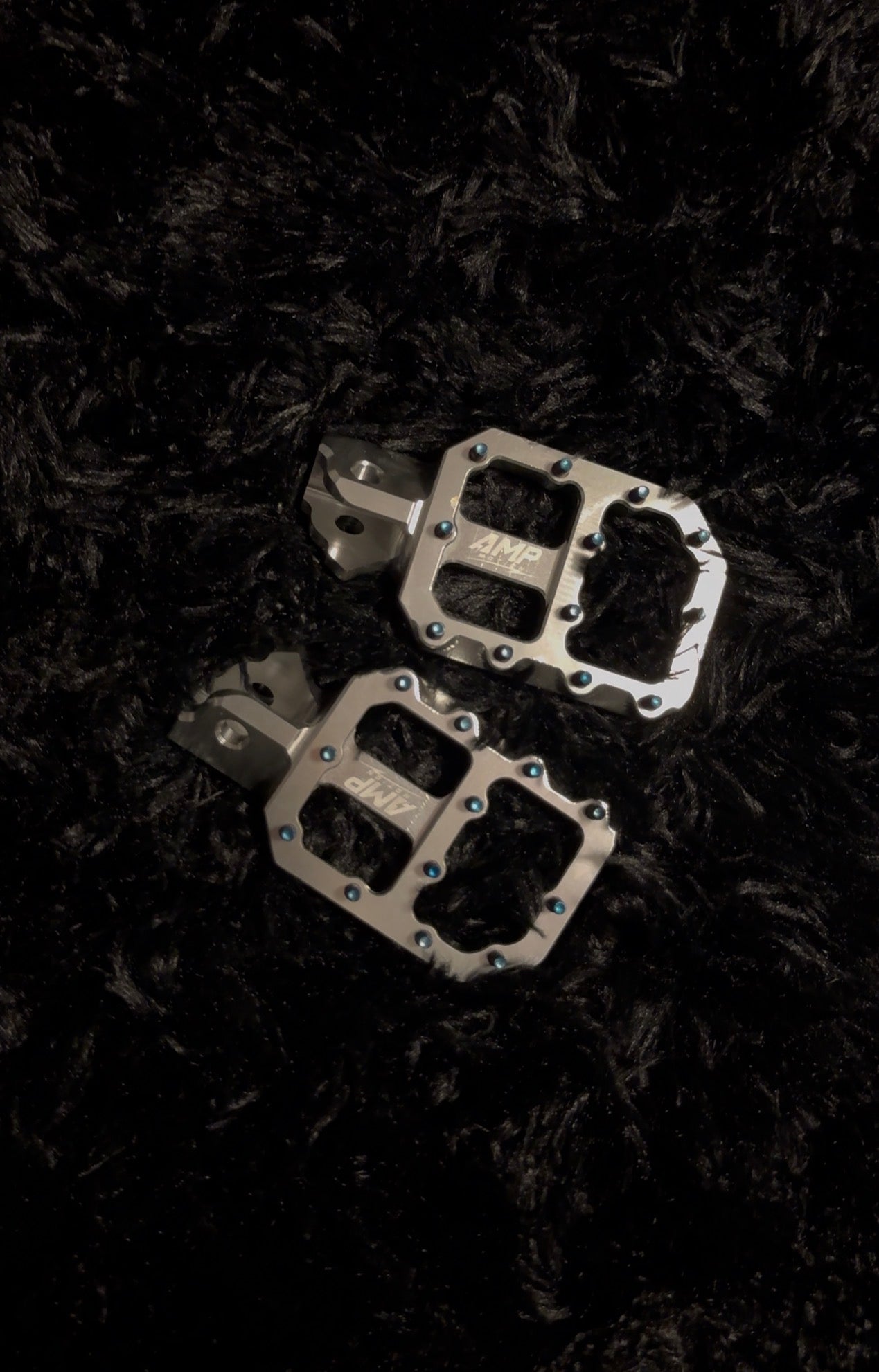 Aluminum pegs from Amp Motion, featuring sleek metal construction and a durable design for bike or skateboard use.