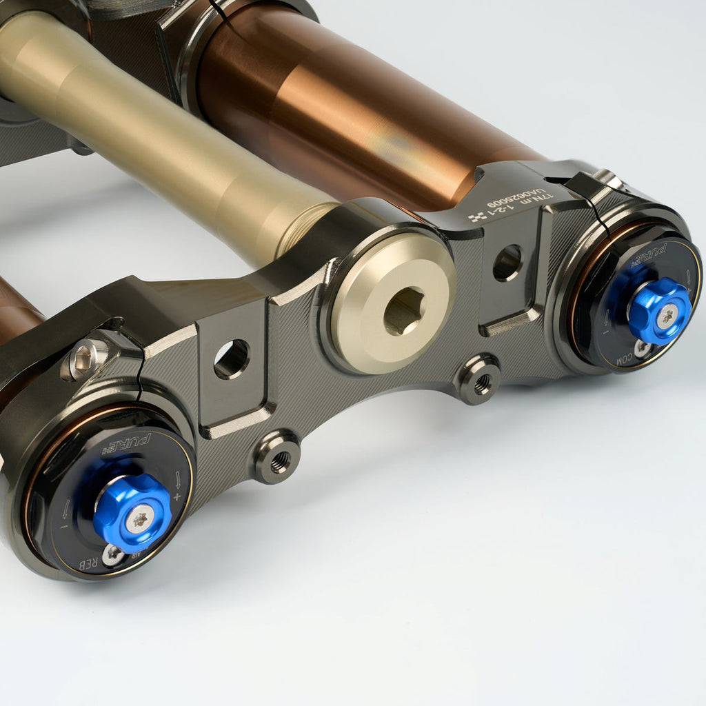 Modded Moto Co Pure Racing Surron Ultra/Talaria Komodo titanium suspension forks, showing close-up of the lowers and suspension components.