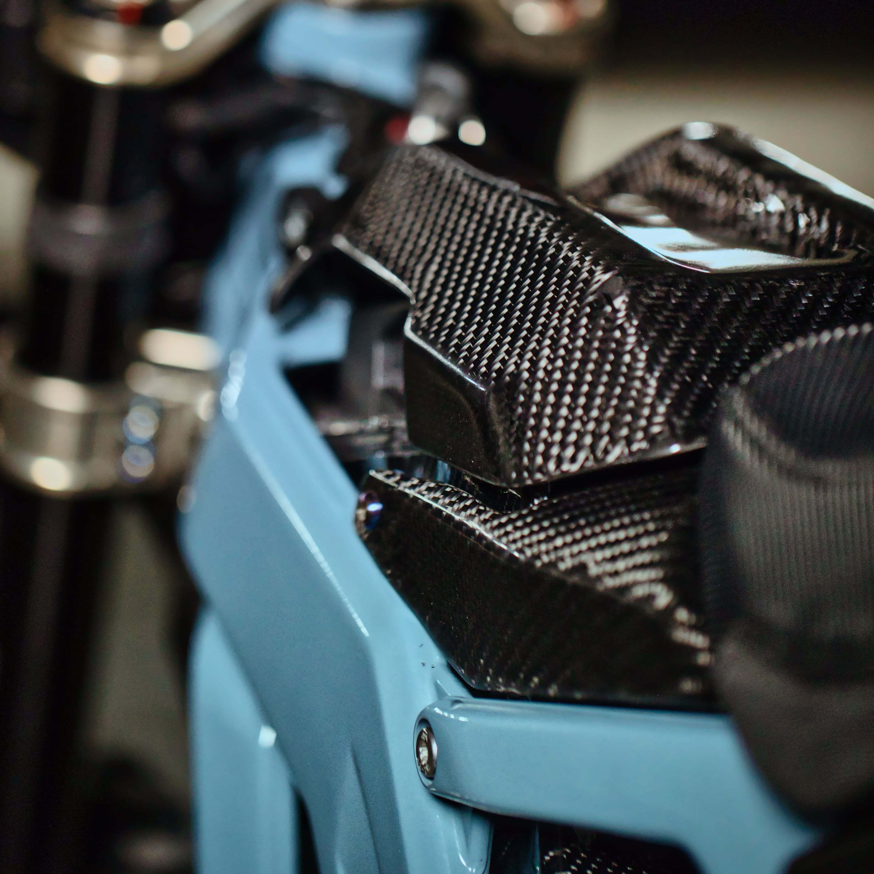 Modded Moto Co E-Ride Pro carbon fiber battery lid lock for e-bike, showcasing sleek design and secure closure in a close-up shot.