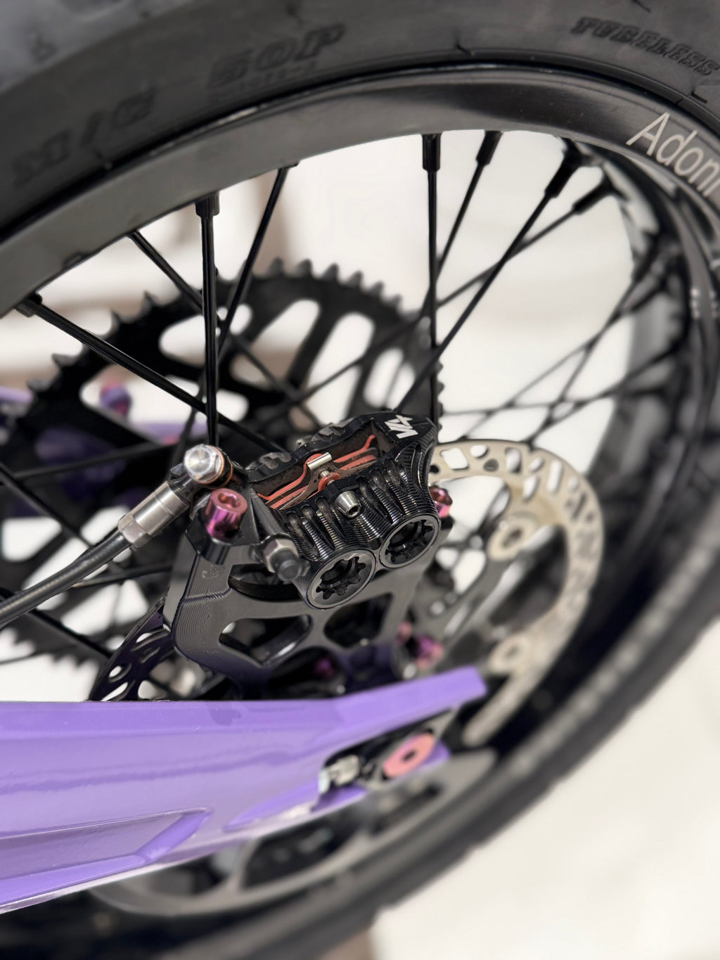 DevMoto titanium caliper mount bolts displayed, showcasing durable, lightweight fasteners for motorcycle brake calipers.