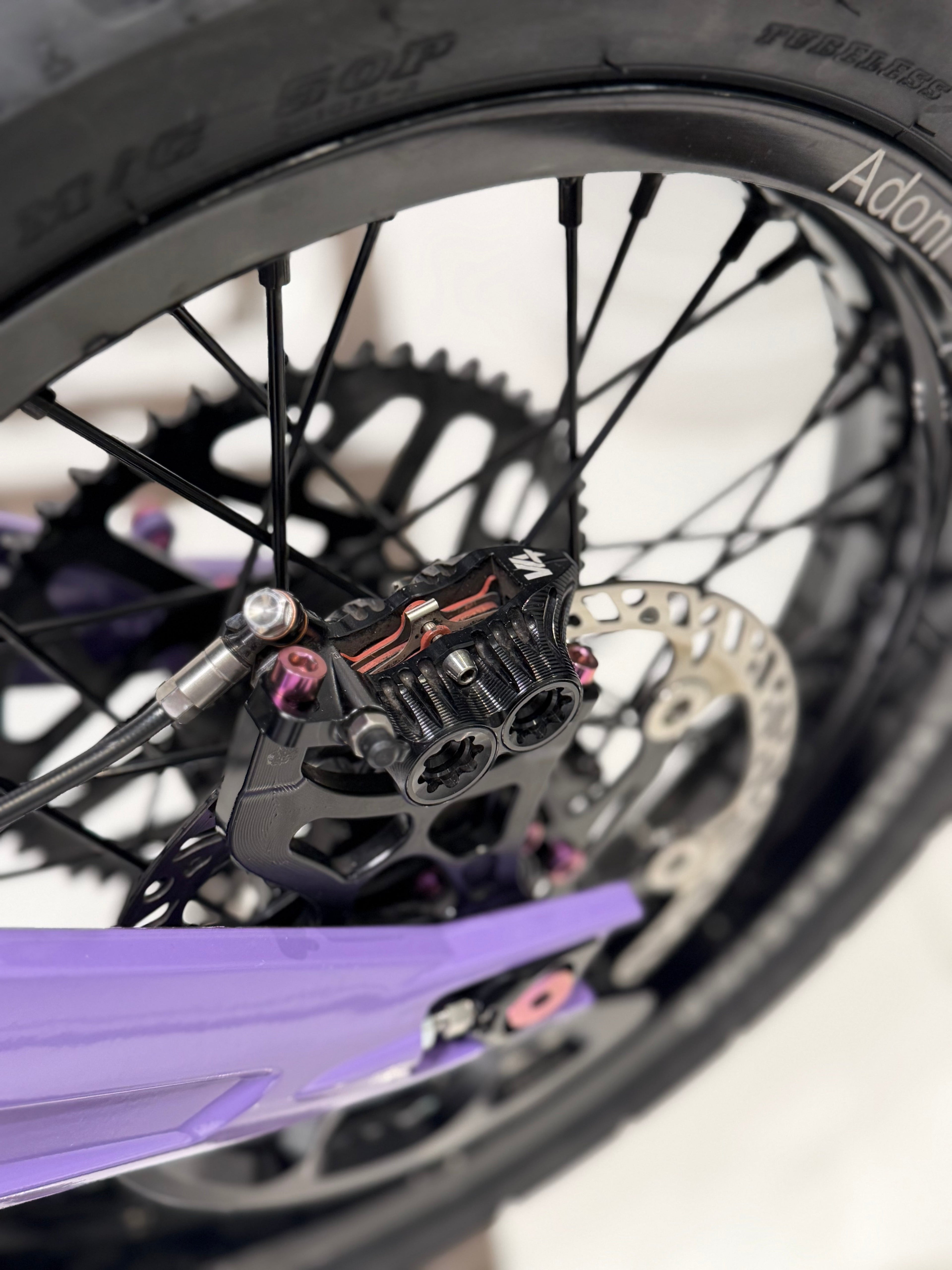 DevMoto titanium caliper mount bolts displayed, showcasing durable, lightweight fasteners for motorcycle brake calipers.