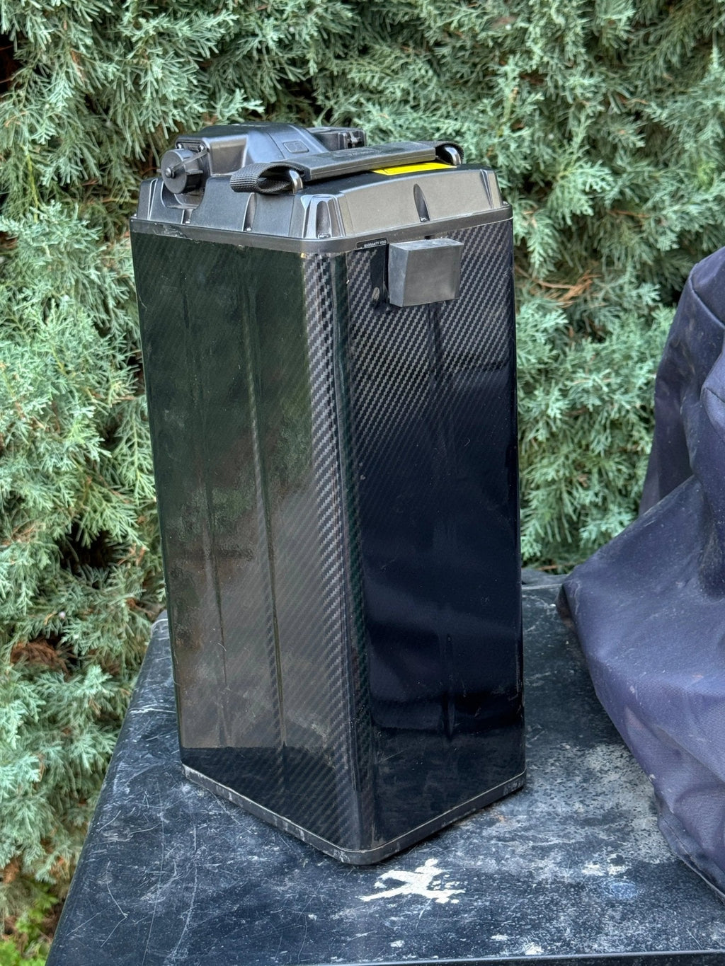 Carbon fiber E-bike battery wrap by MXwraps, showing the vinyl wrap on the back corner of the battery for a sleek, protective finish.