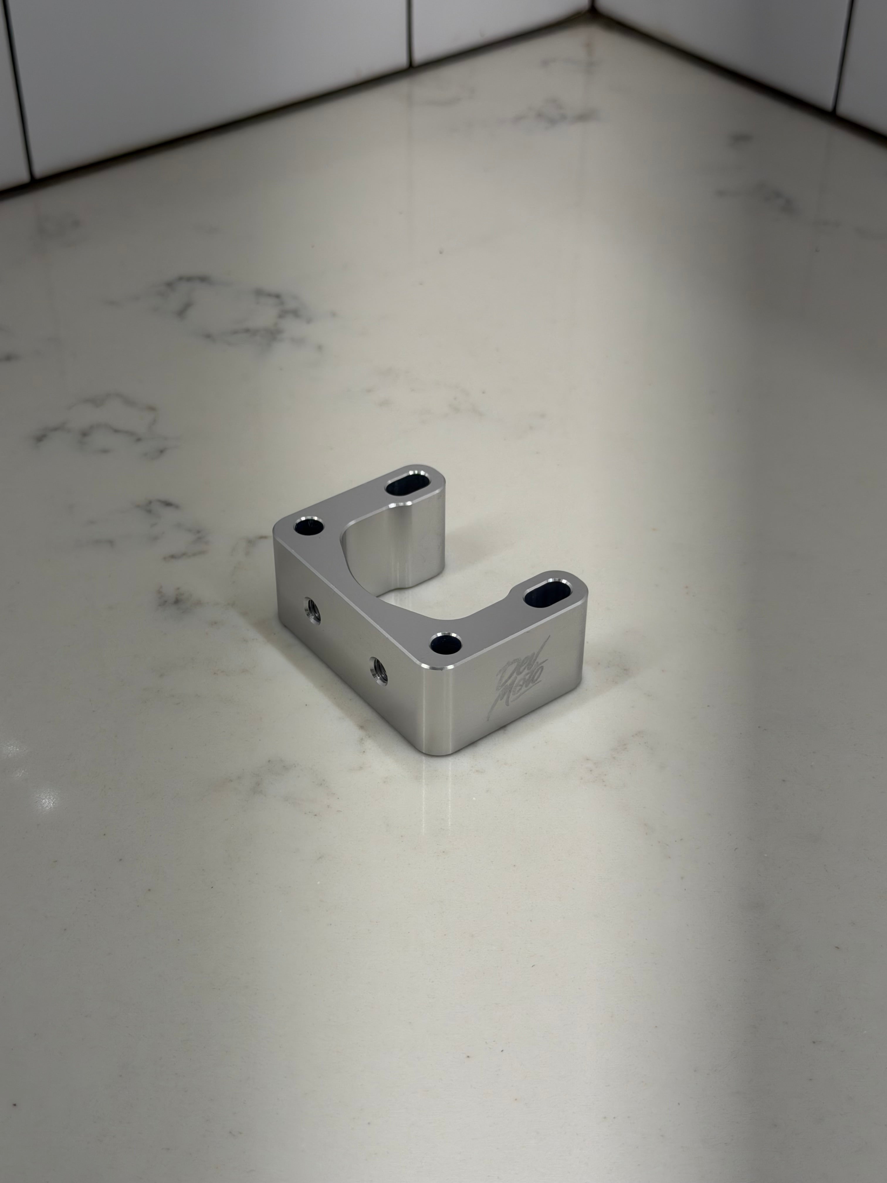 DevMoto direct mount riser bracket for motorcycle handlebars, showcasing sturdy metal construction and mounting hardware.