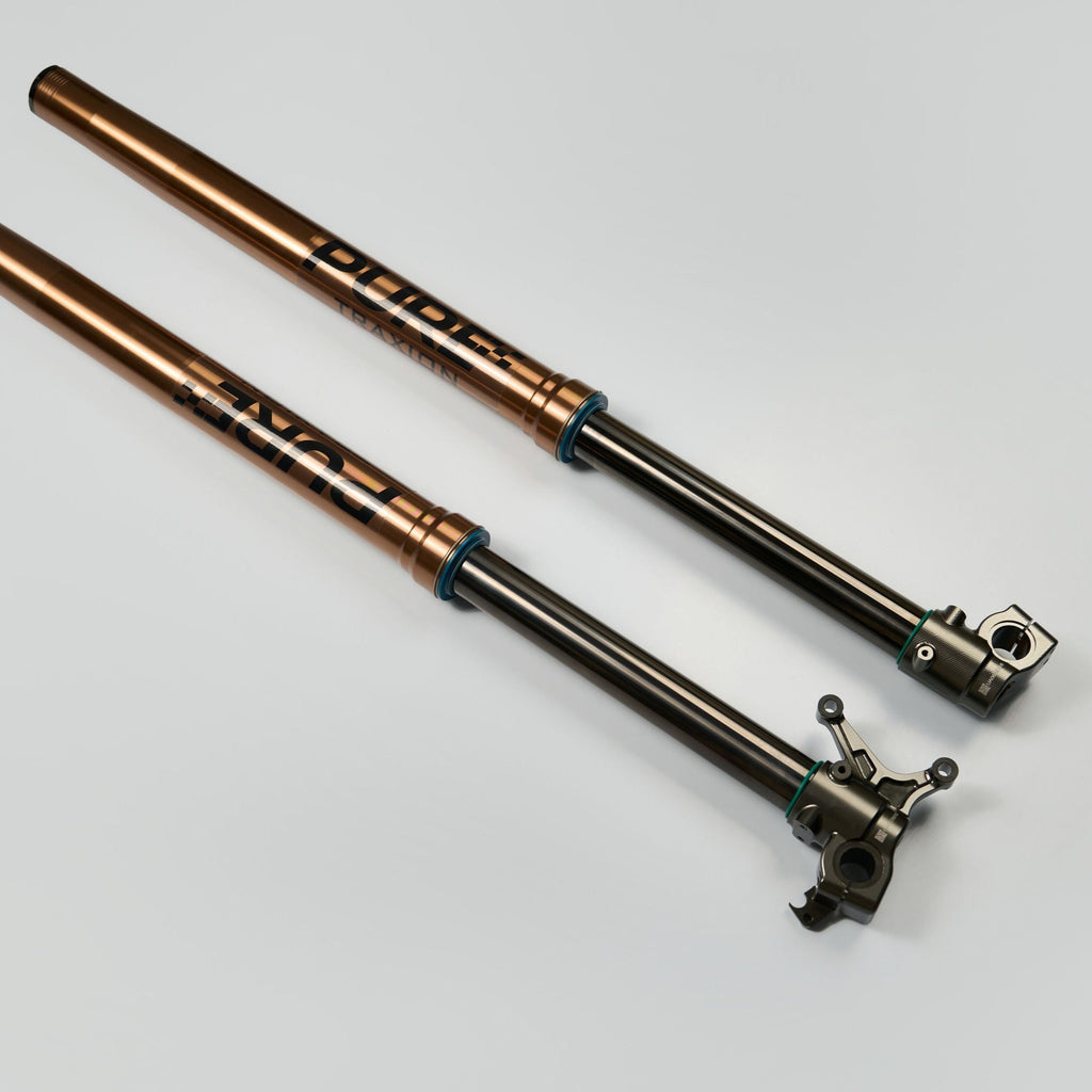 Modded Moto Co Pure Racing Surron Ultra and Talaria Komodo suspension forks on a motorcycle for enhanced off-road performance.