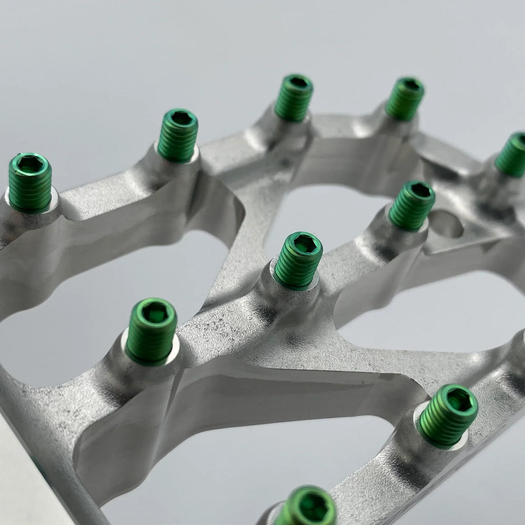 Warp 9 Titanium Elite foot peg screws, titanium bolts by Modded Moto Co, shown installed on motorcycle foot pegs.