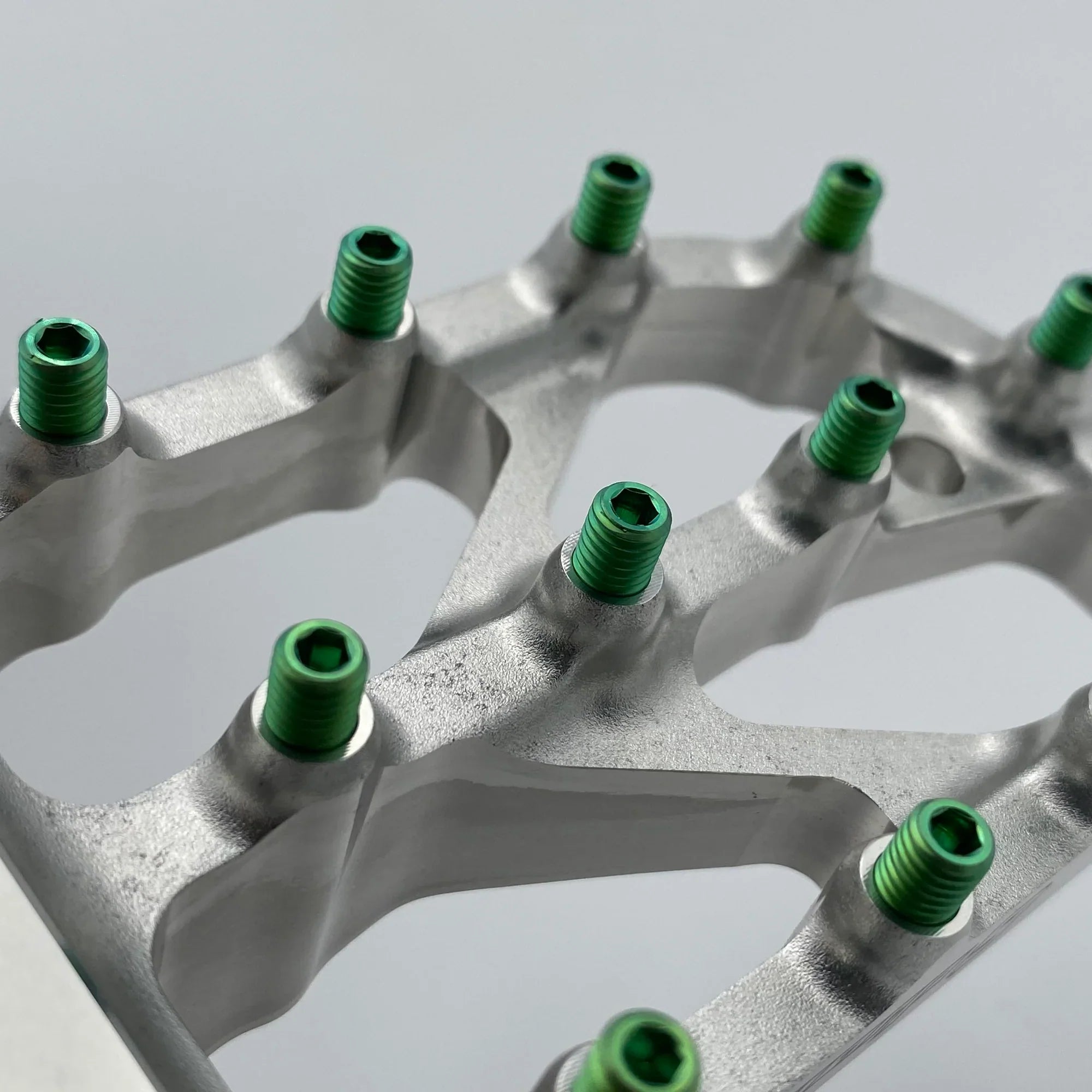 Warp 9 Titanium Elite foot peg screws, titanium bolts by Modded Moto Co, shown installed on motorcycle foot pegs.
