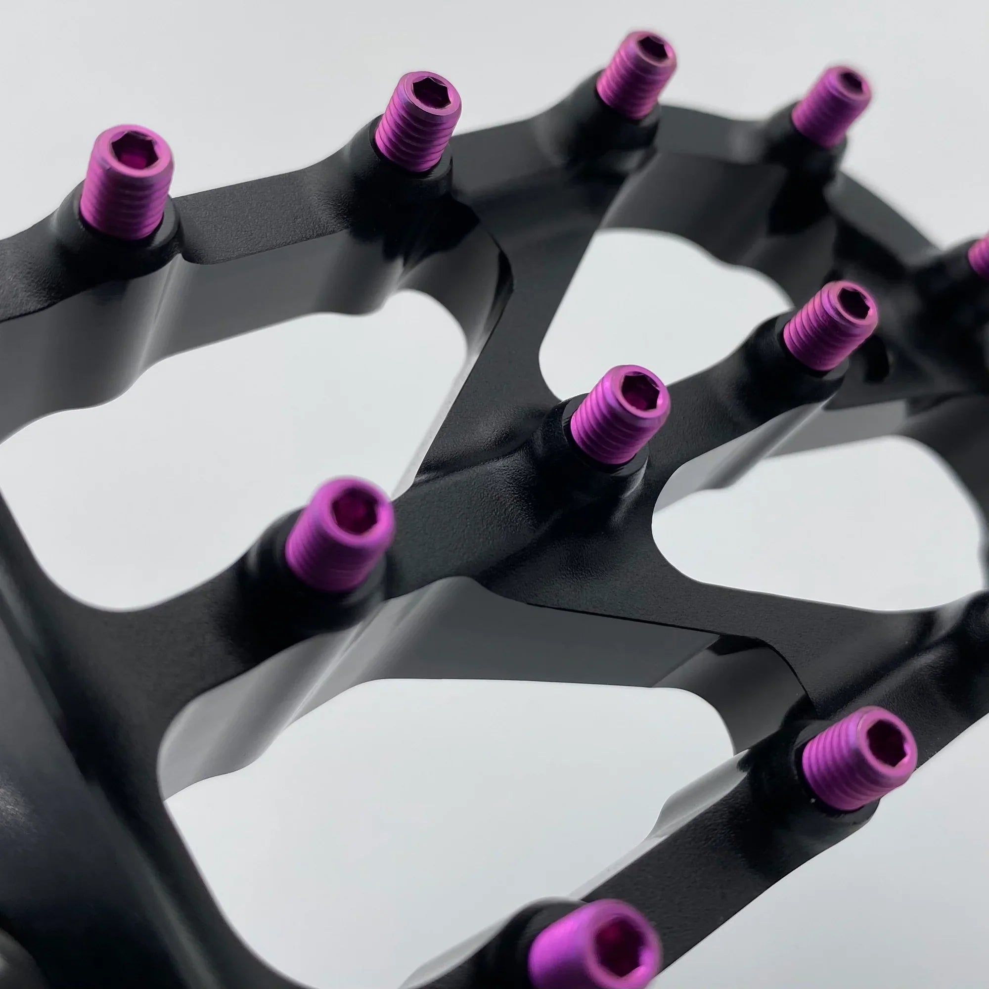 Close-up of Warp 9 Titanium Elite foot peg screws by Modded Moto Co, showcasing durable titanium bolts with detailed threading.