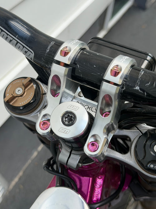 Set of four DevMoto direct mount riser bolts for motorcycle handlebars with threaded ends and hex heads.