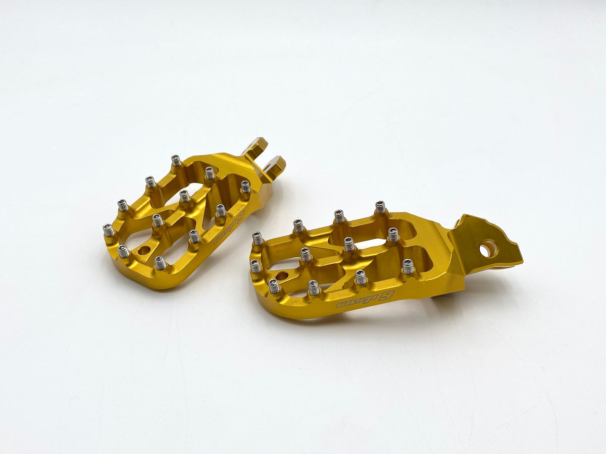 Modded Moto Co Warp 9 Talaria and Sigma Elite foot pegs mounted on motorcycle, showcasing durable metal construction and sleek design.