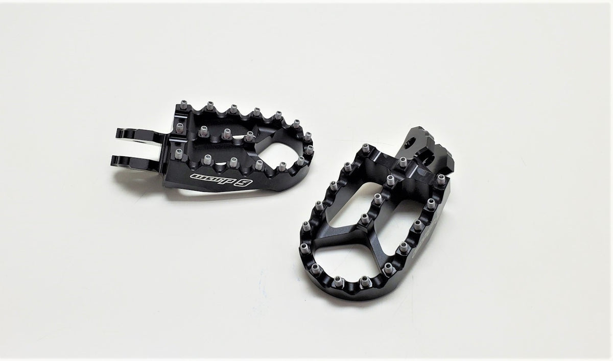 Modded Moto Co Warp 9 Talaria and Sigma foot pegs for motorcycle, durable metal construction with textured grip surfaces.