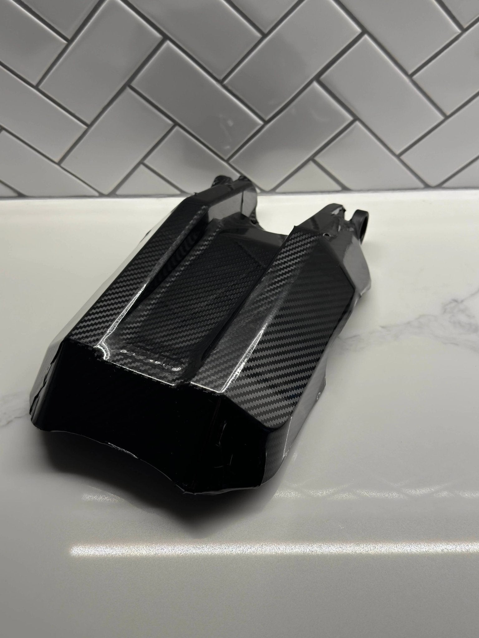 MXwraps E Ride Pro carbon fiber vinyl wrap kit shown on a vehicle, featuring a sleek, textured carbon fiber finish for custom automotive styling.