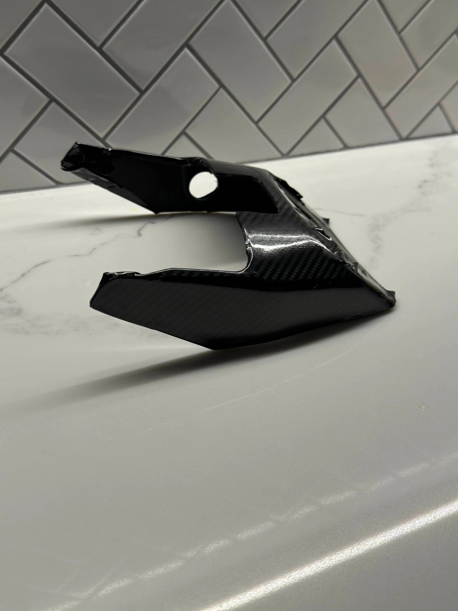 MXwraps E Ride Pro carbon fiber vinyl wrap kit applied to a vehicle, showcasing a sleek, textured carbon fiber finish.