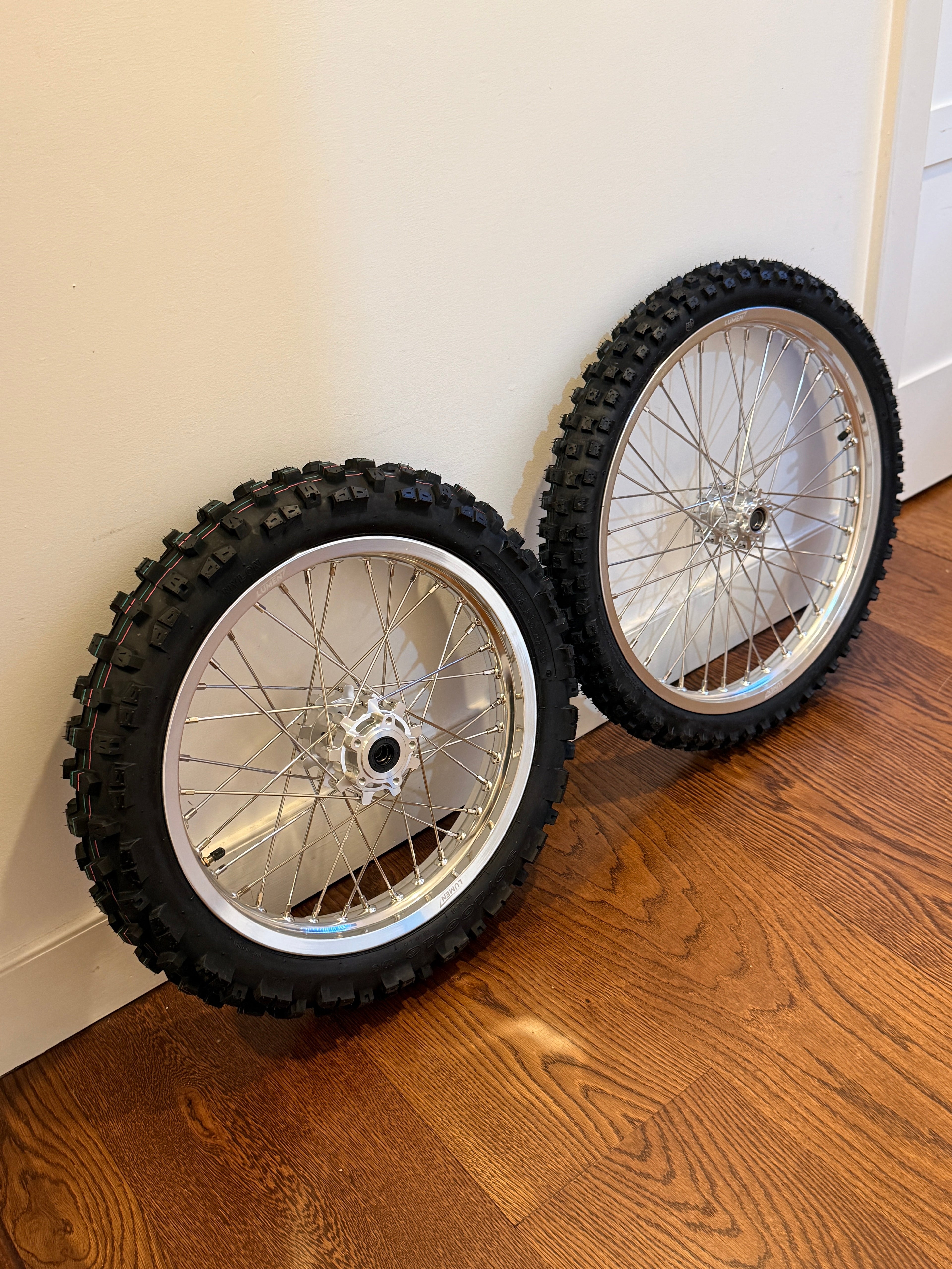 Lumen Racing Light Bee/Eride Pro wheelset with 16/19 inch rims and dirt tires, ready for mountain biking adventures.