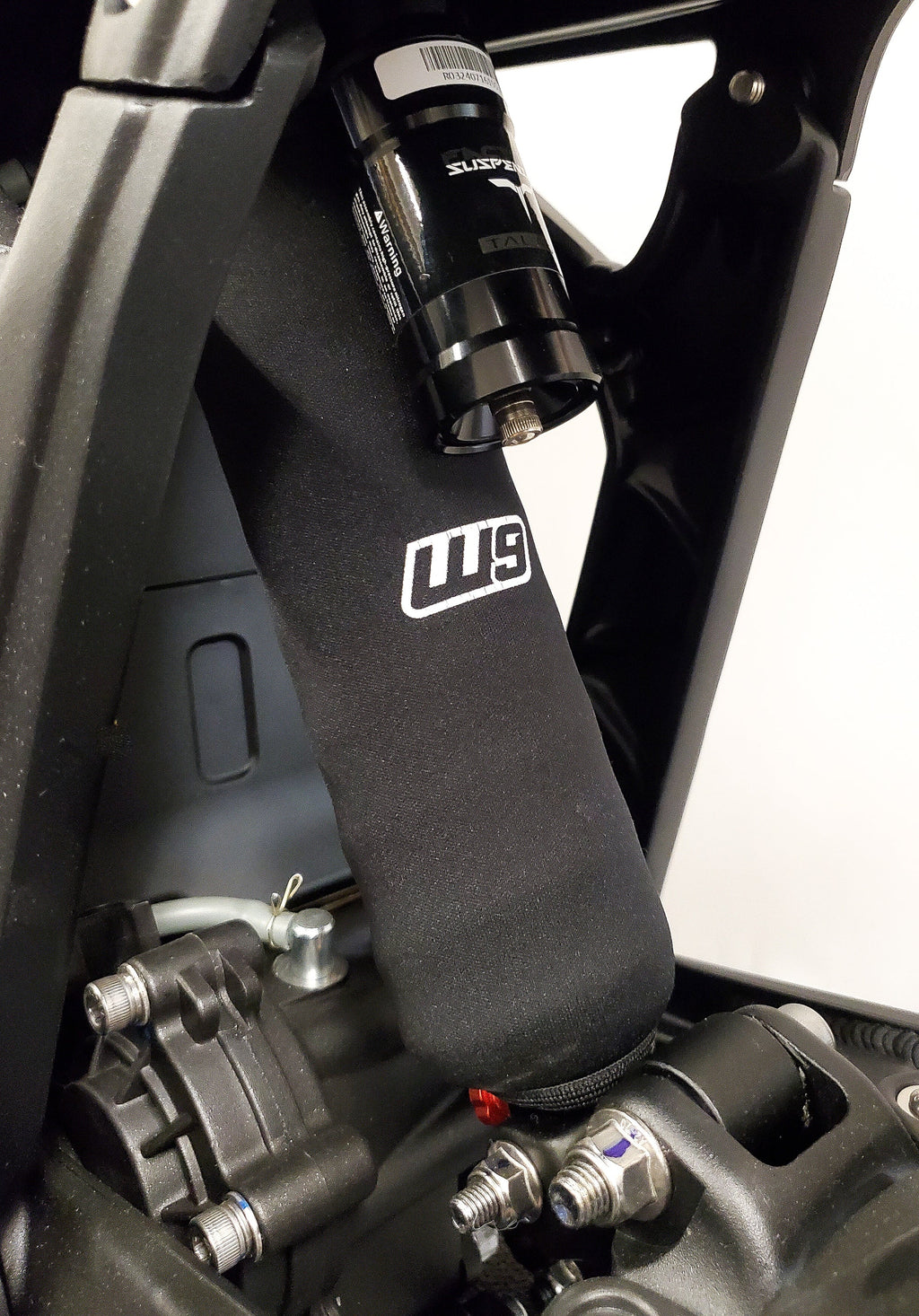 Modded Moto Co Warp 9 shock cover installed on motorcycle, providing body protection and a sleek look for shocks.