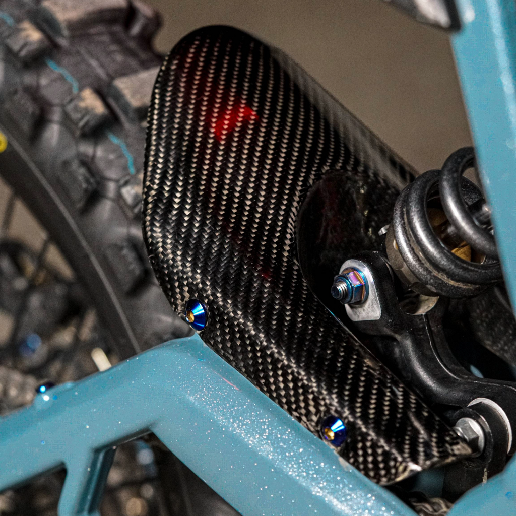 Modded Moto Co E-Ride Pro carbon fiber mud guard for electric bikes, lightweight protective body accessory with sleek design.