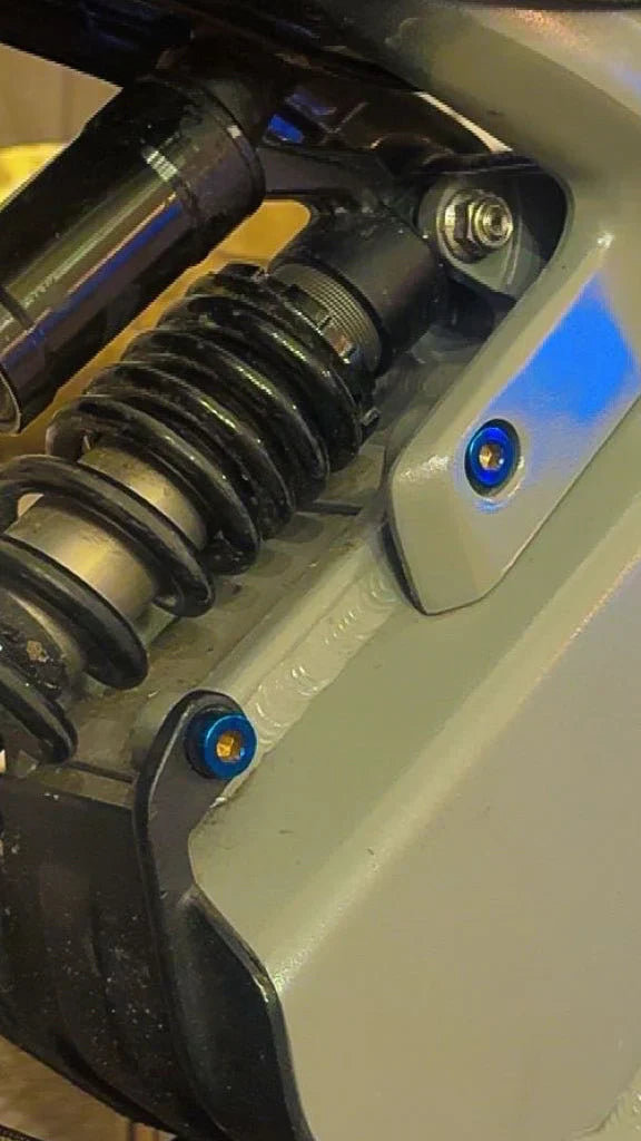 Set of two DevMoto Talaria XXX battery hatch bolts, showing secure metal fasteners for motorcycle battery access.