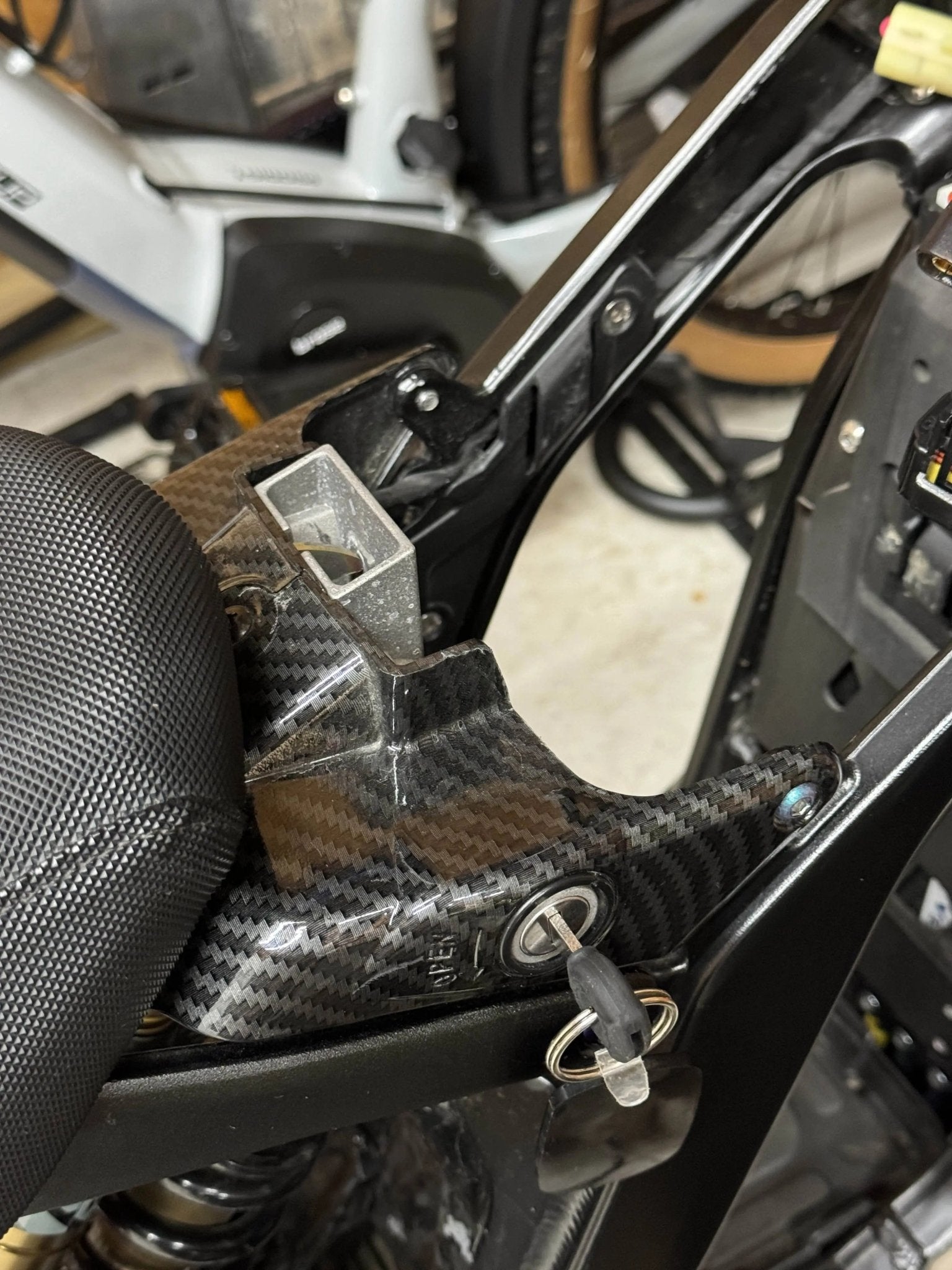 Side view of Surron LBX electric bike with MXwraps carbon fiber vinyl wrap on battery side panels.